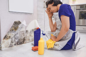 Close-up Of A Shocked Woman Looking At Mold On Wall